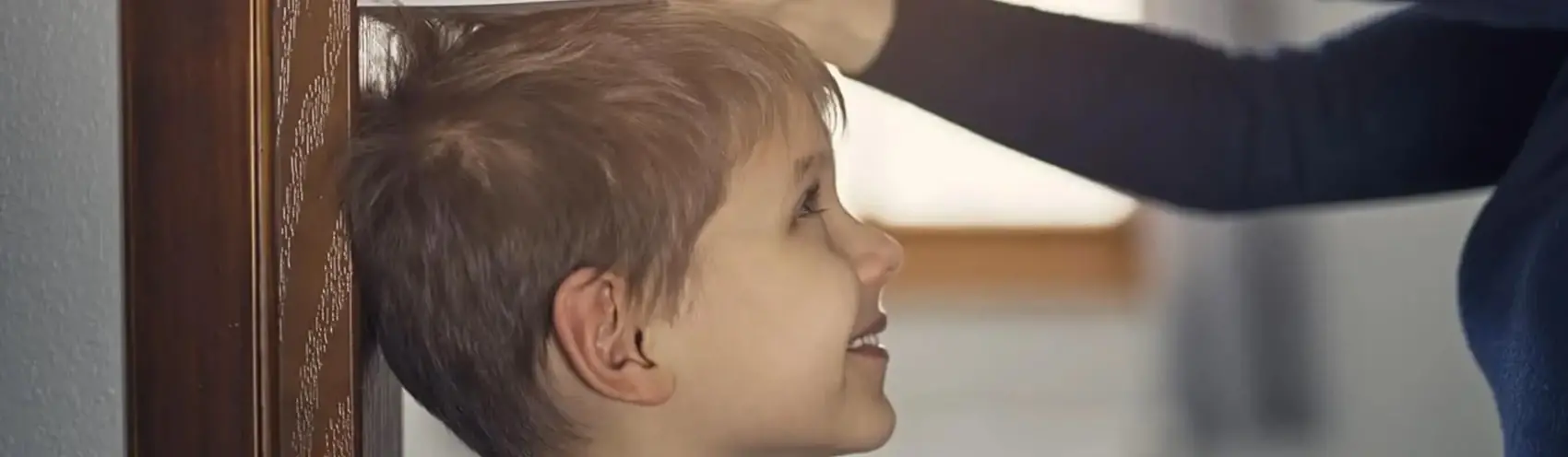 Adulto tomando nota de la altura de un niño Adulto tomando nota de la altura de un niño