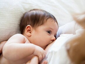 Una madre amamanta a su pequeña bebé.