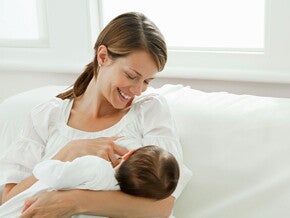 Una madre se alista para empezar a amamantar a su bebé. 