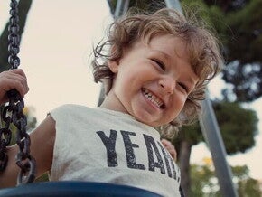 Nene contento jugando en columpio