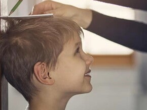 Adulto tomando nota de la altura de un niño