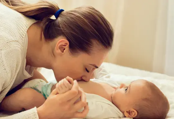 Mama dando besos a panza de bebe