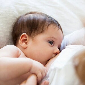 Una madre amamanta a su pequeña bebé.