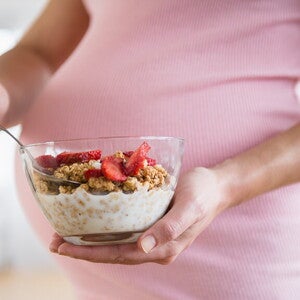 Mujer adolescente embarazada comiendo