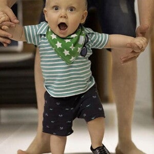 Papa ayudando a su hijo a caminar