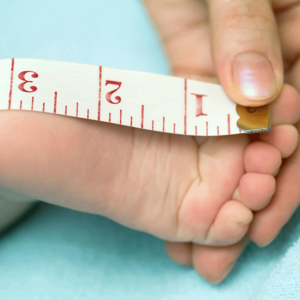 Medico midiendo el pie de un bebe