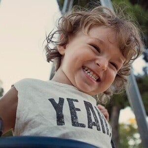 Nene contento jugando en columpio