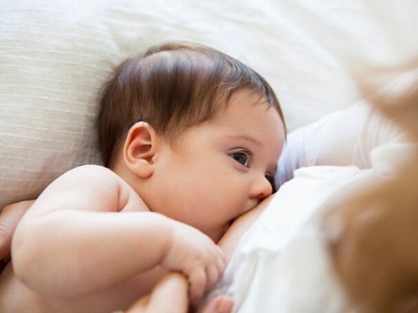 Una madre amamanta a su pequeña bebé.