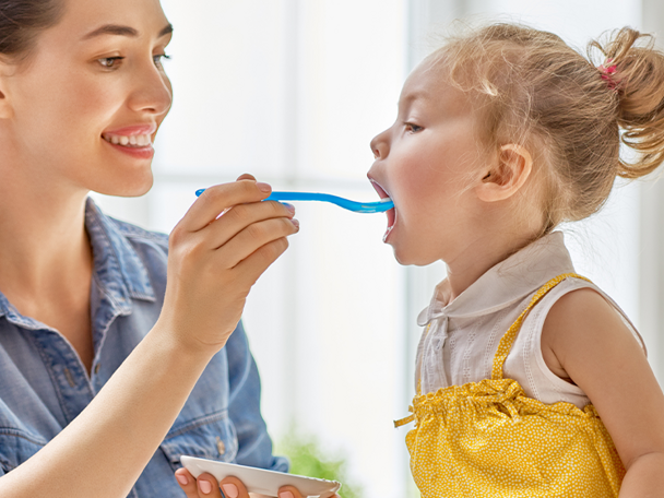 Mamá dando de comer a su hija