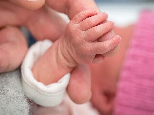 Bebe con bajo peso agarrando el dedo