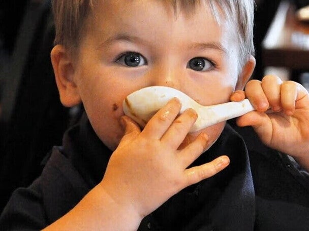 Niño tomando sopa con una cuchara