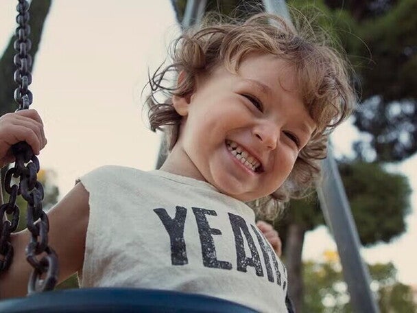 Nene contento jugando en columpio