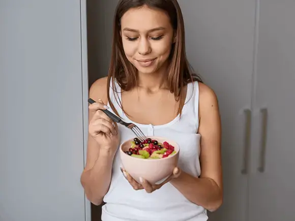 Nutrición para el control de síndrome ovario poliquístico Mujer consumiendo una dieta nutritiva